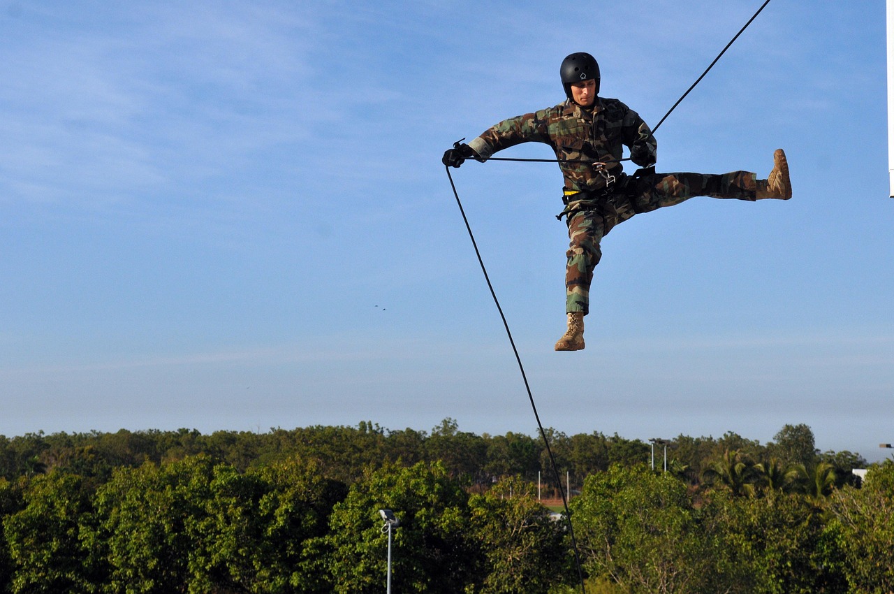 Climber secured high in a tree preparing to lower a limb